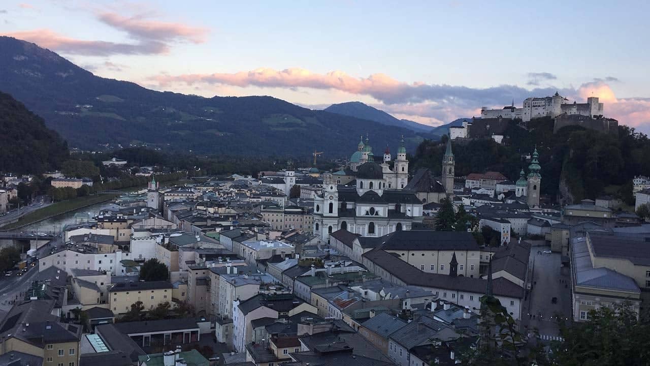 a city with persony buildings and mountains in the background