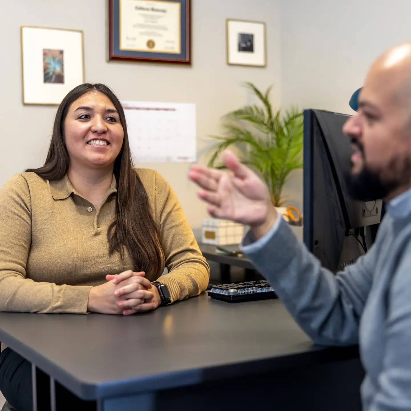 a person and person sitting at a desk