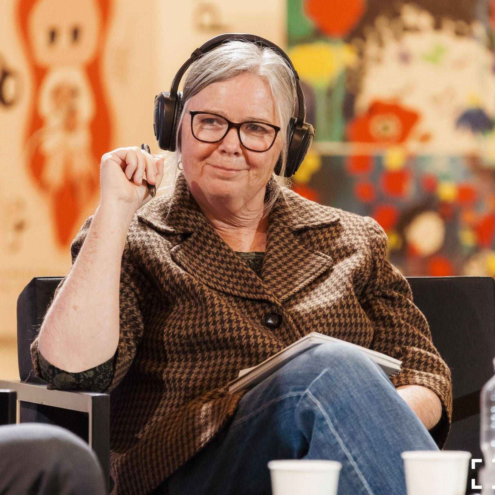 a person wearing headphones and holding a pen