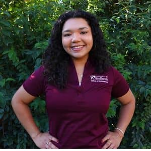 a person smiling with her hands on her hips