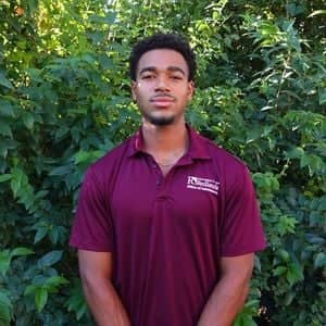 a person standing in front of bushes