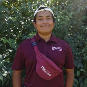 a person wearing a red shirt and white cap
