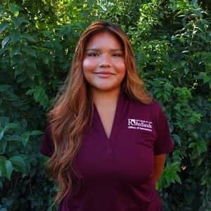 a person standing in front of bushes