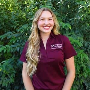 a person smiling in front of trees