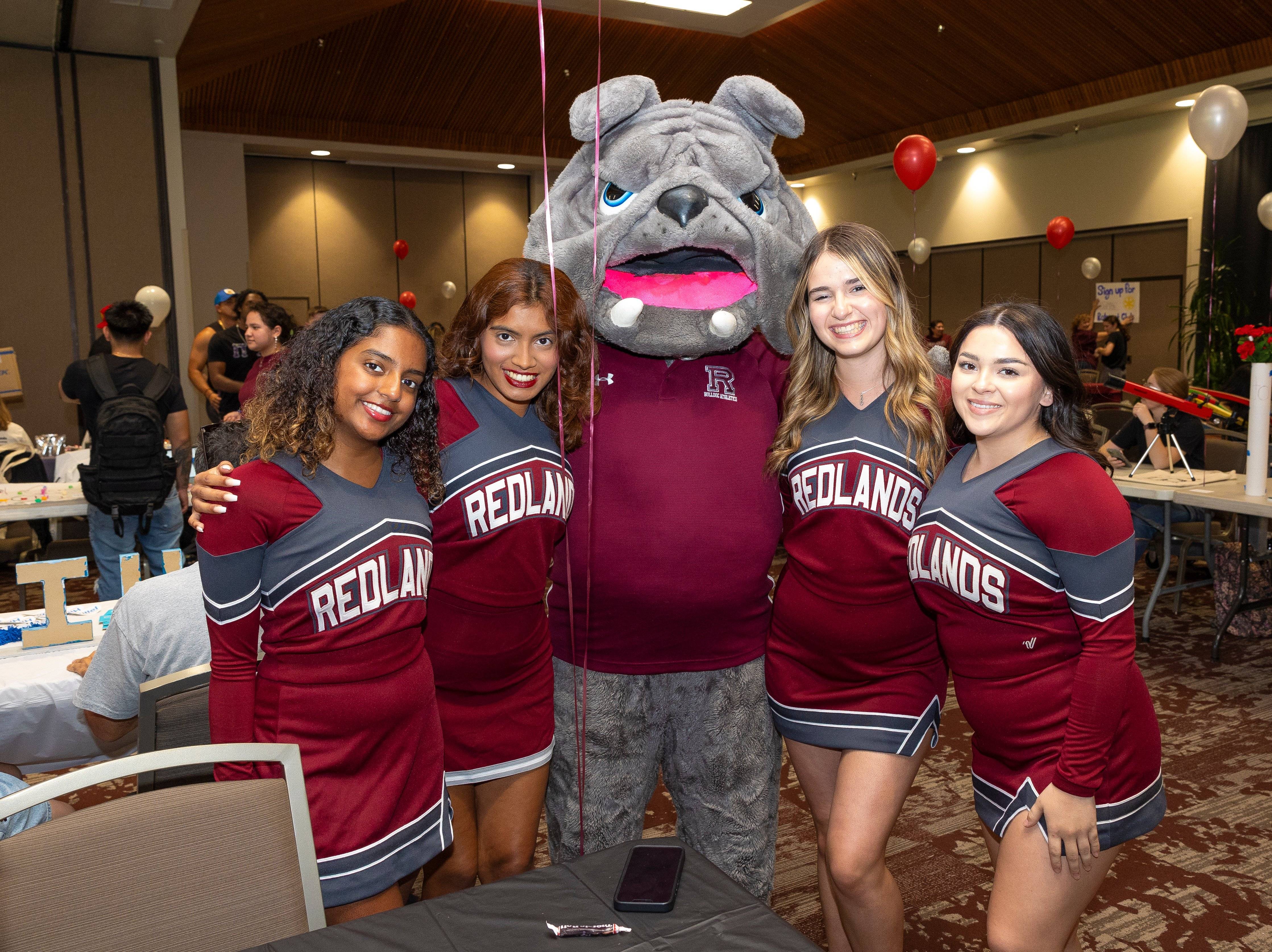 a group of women posing with a mascot
