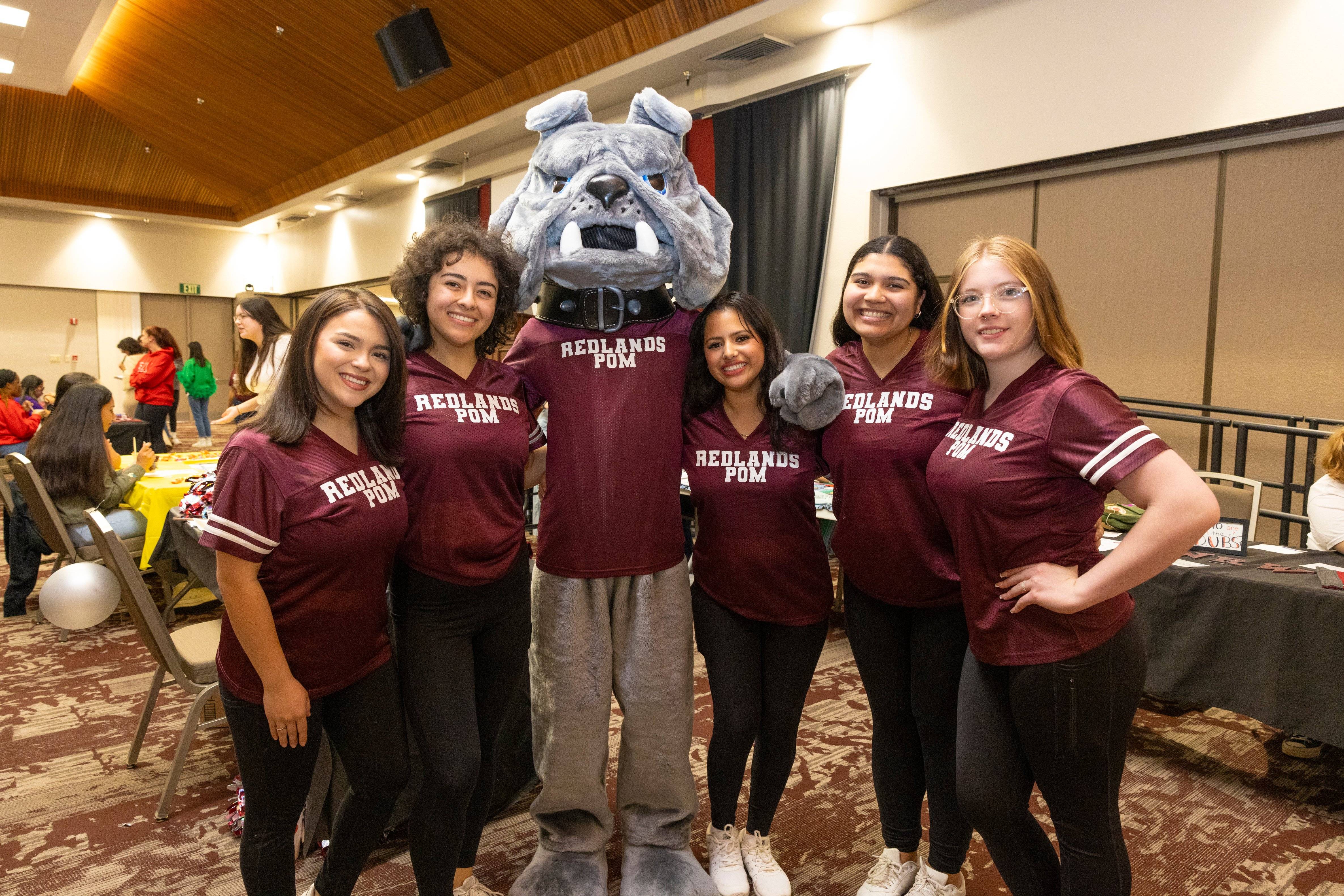 a group of women posing with a mascot