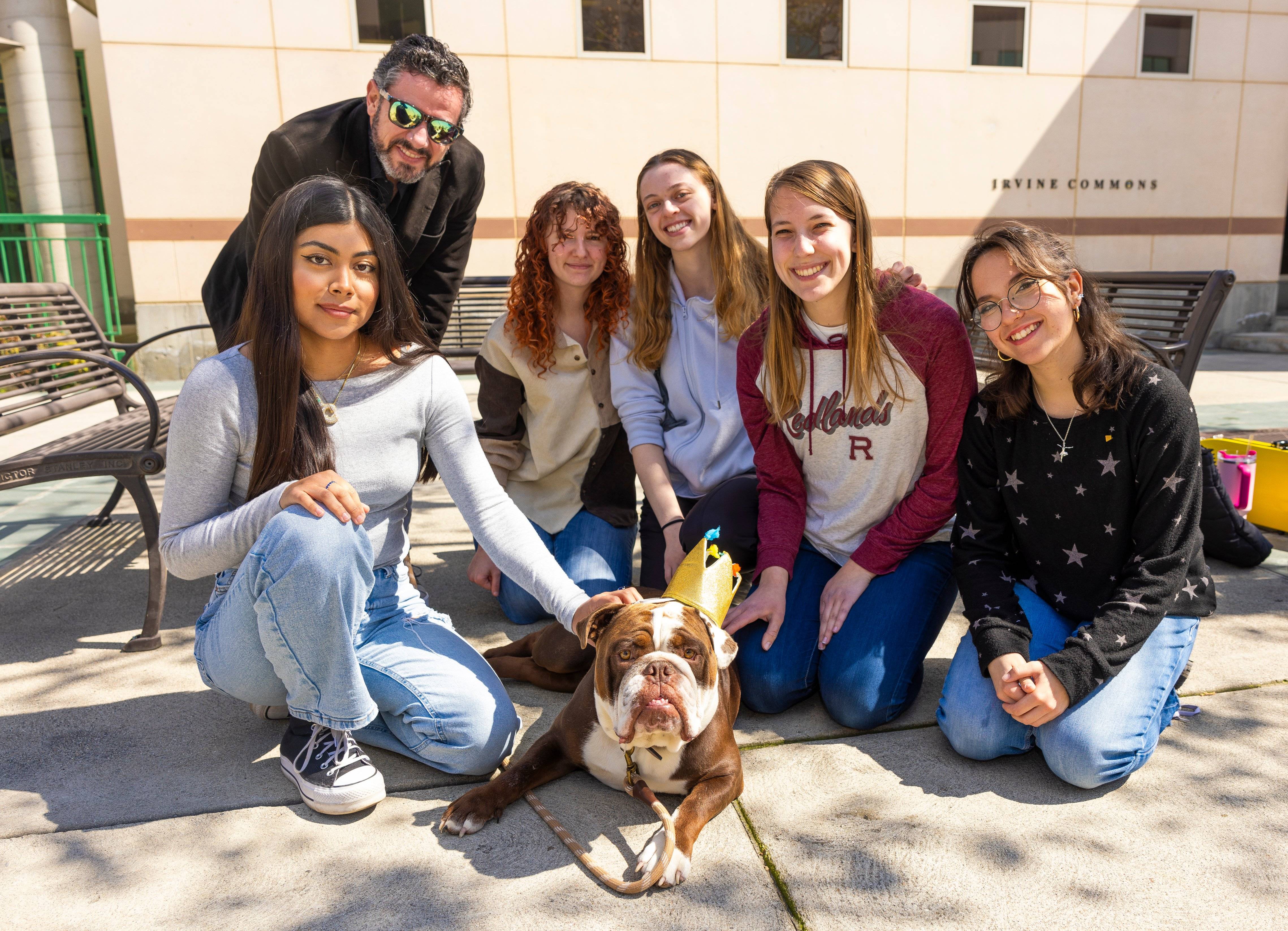 a group of people posing for a picture with a dog