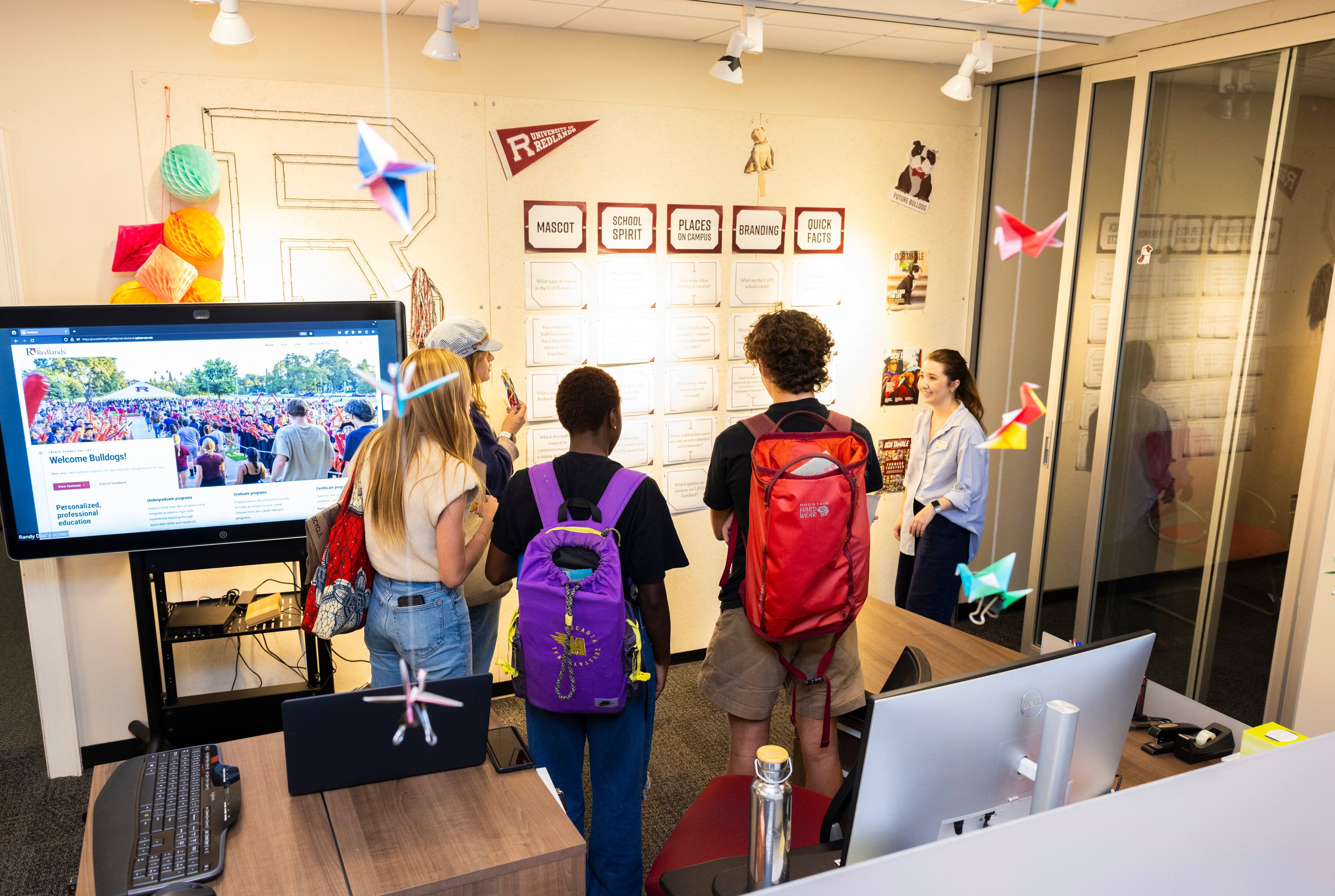 a group of people looking at a wall with a screen