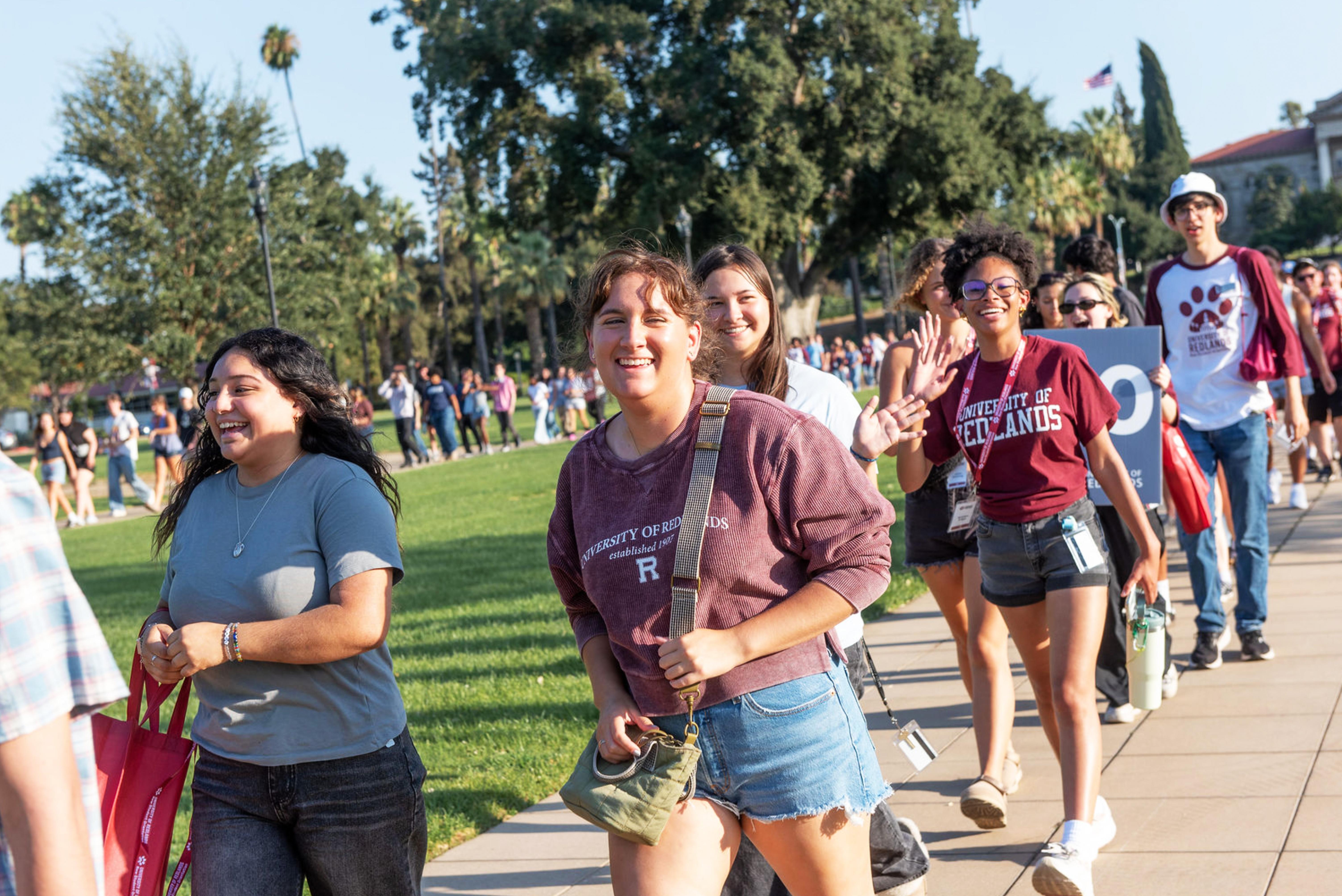 a group of people walking on a sidewalk