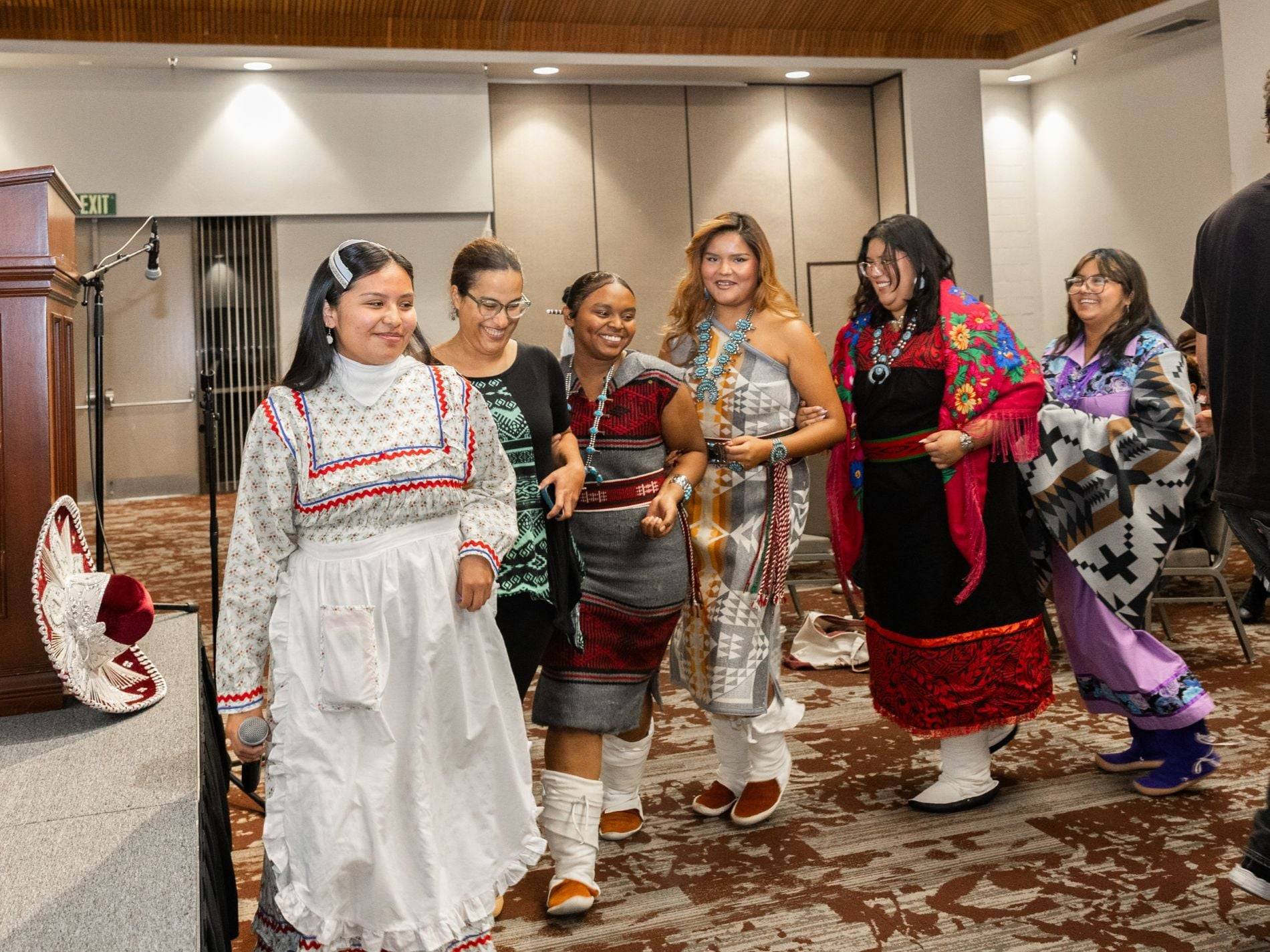 A group of students dressed in traditional regalia dance together at the Culture Not Costume event.