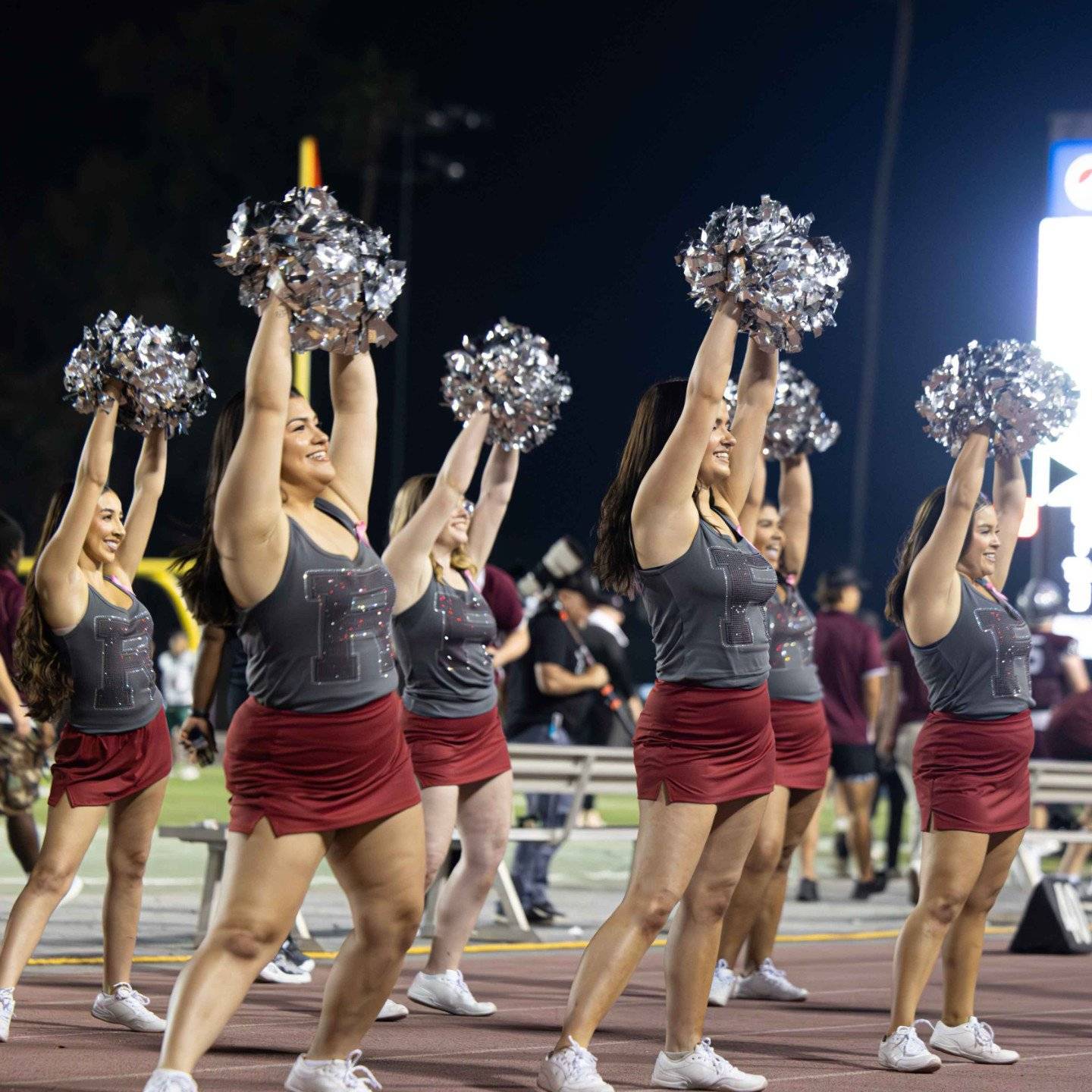 a group of cheerleaders holding pom poms