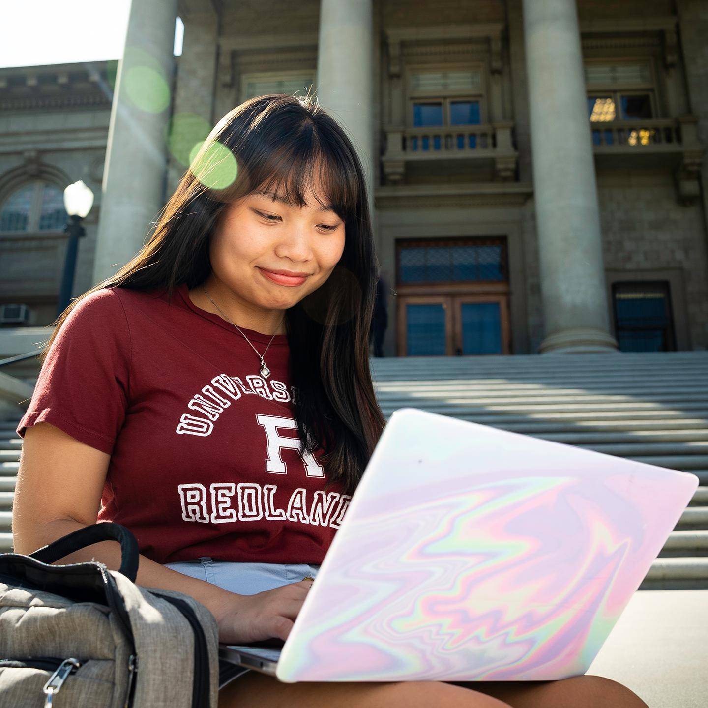 a person sitting on steps with a laptop