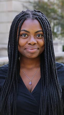 a person with long braids smiling