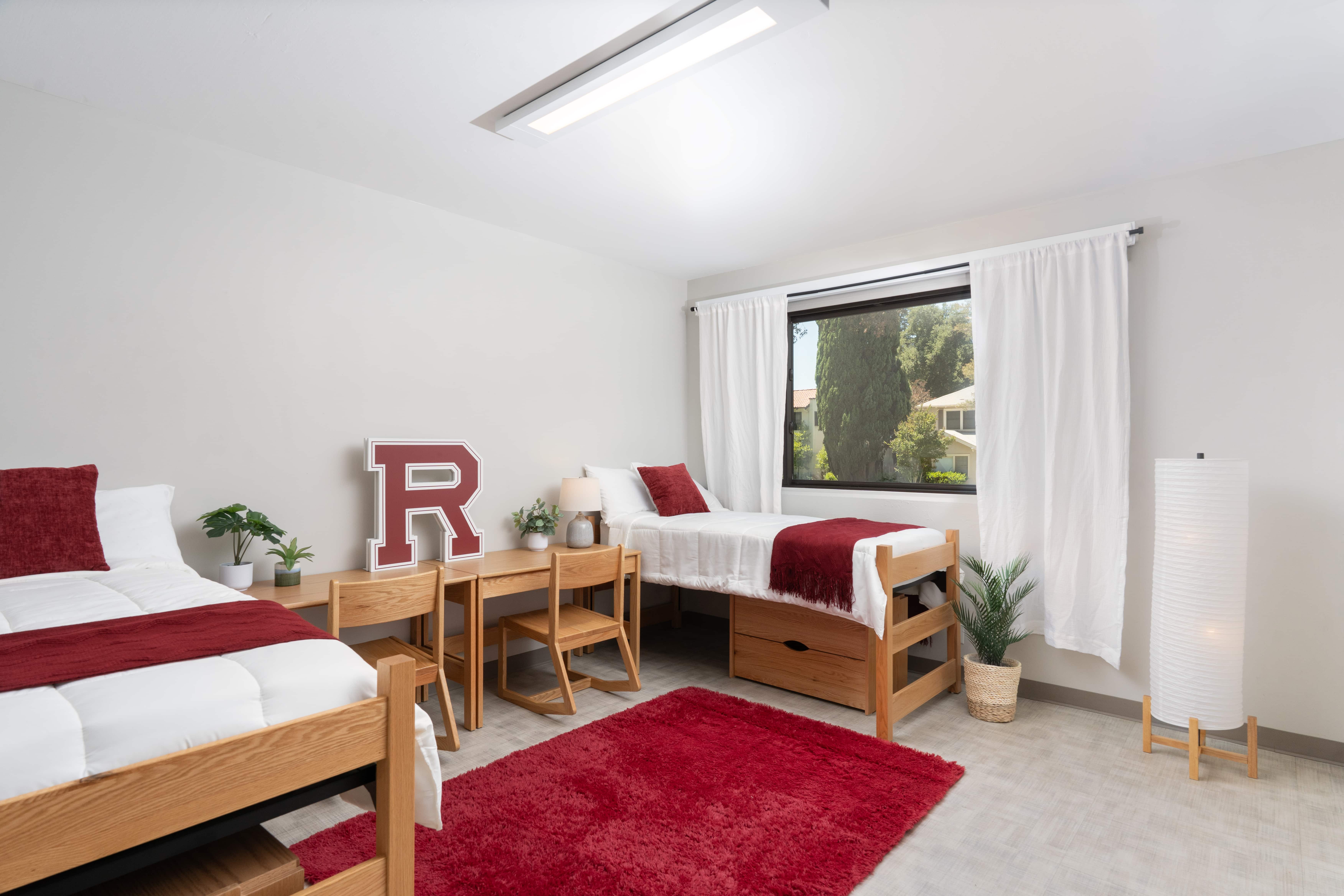 a room with two beds and a red rug