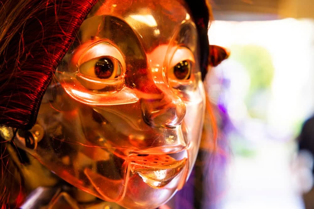 a plastic face mask with a red hat