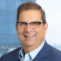 a person wearing glasses and a suit