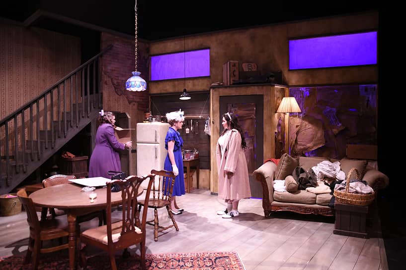 a group of women in a room with furniture and a table