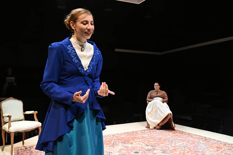 a person in blue dress and blue dress standing on a stage
