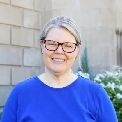 a woman wearing glasses smiling
