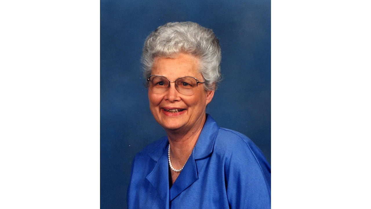 a woman wearing a blue shirt and glasses