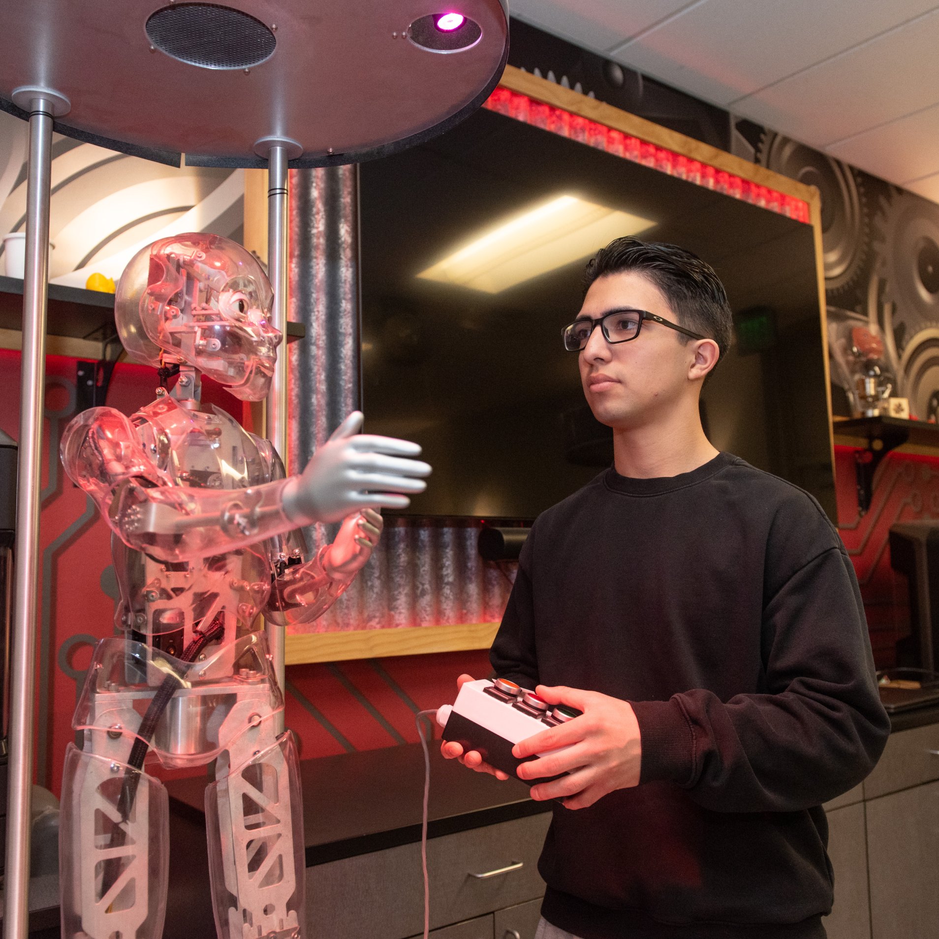 a person holding a controller next to a robot