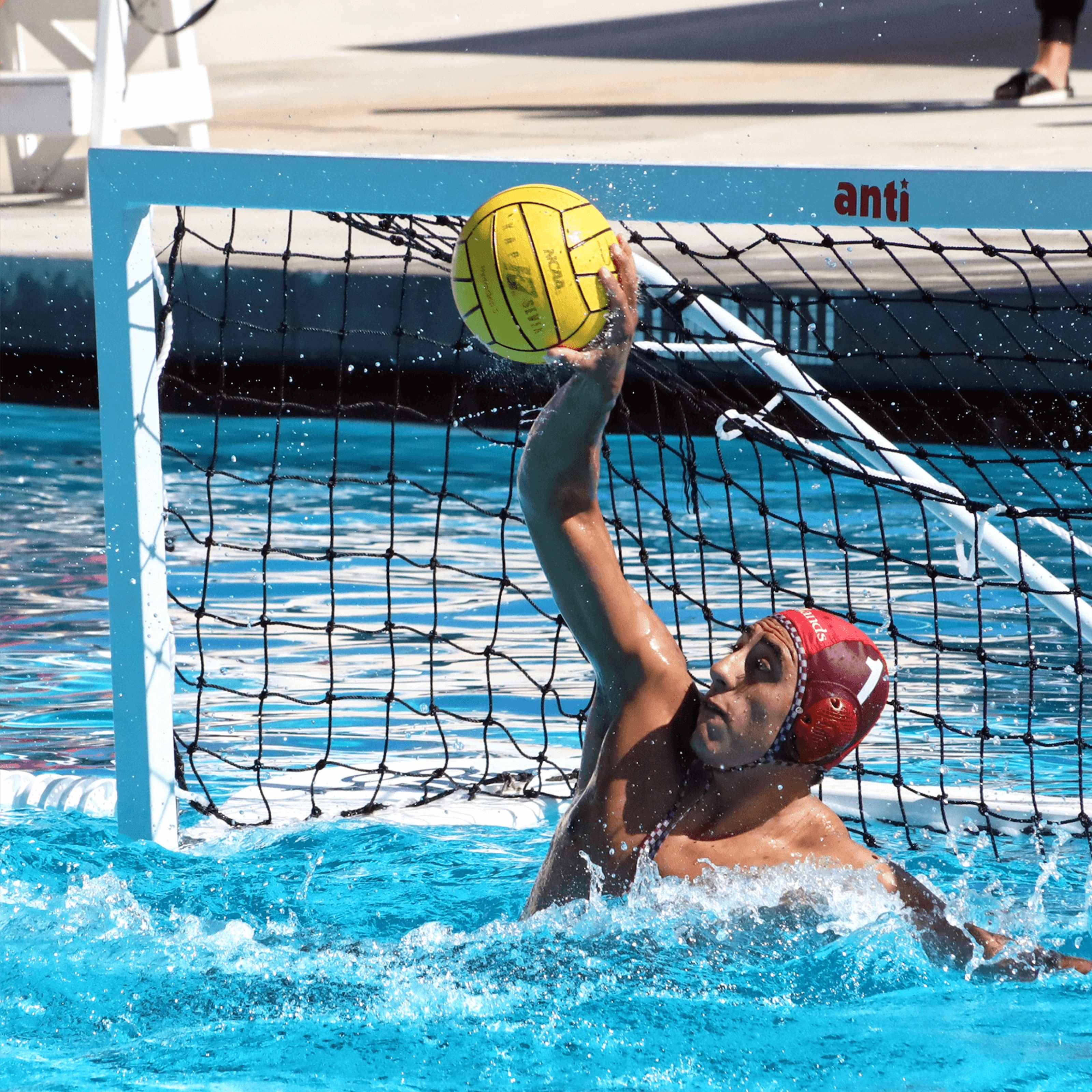 A student athlete in a pool playing water polo