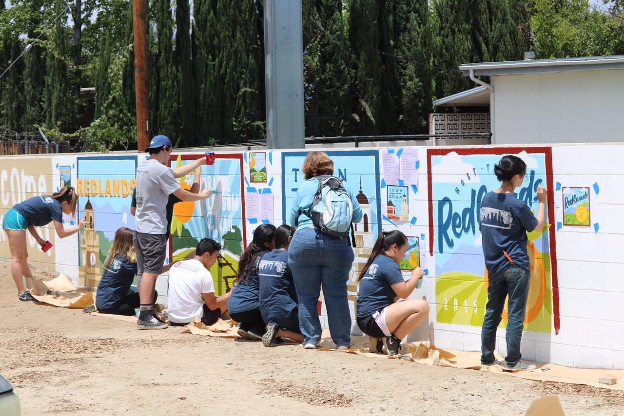 a group of people painting a wall