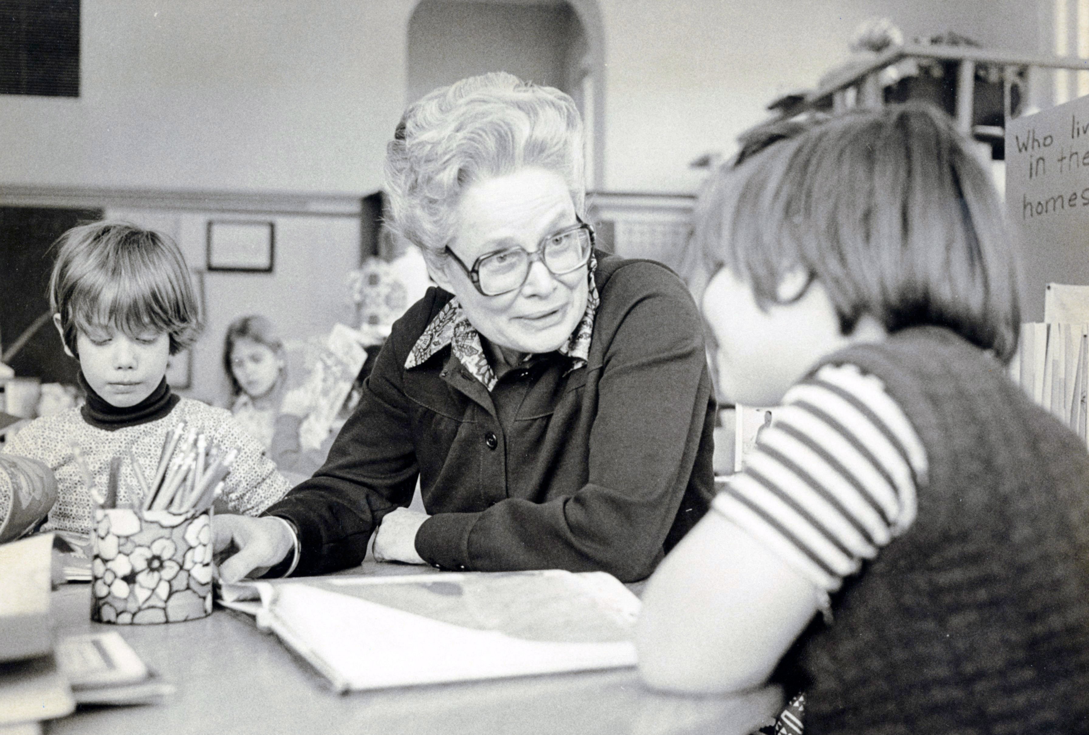 a woman and children sitting at a table