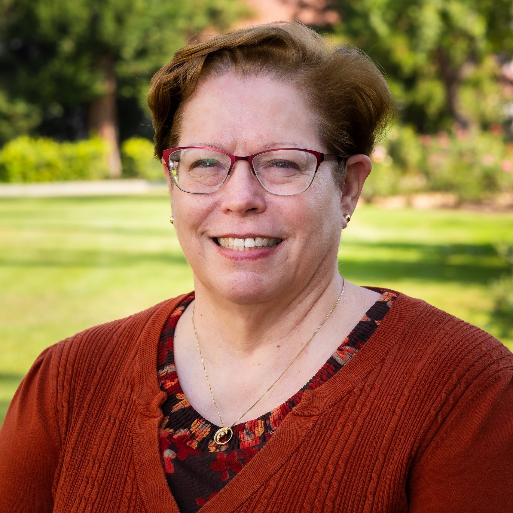 a woman wearing glasses and a sweater