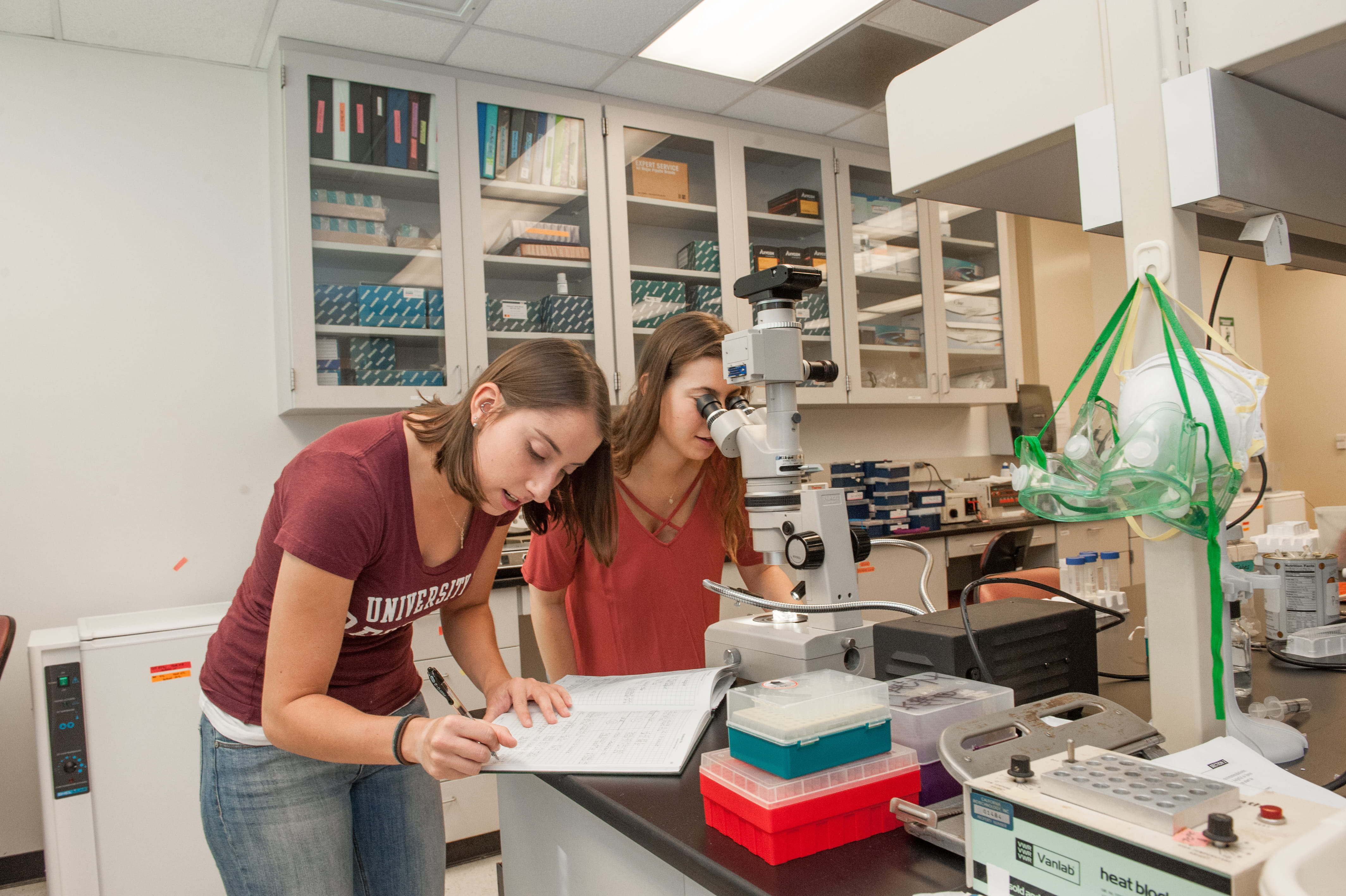 a woman looking through a microscope