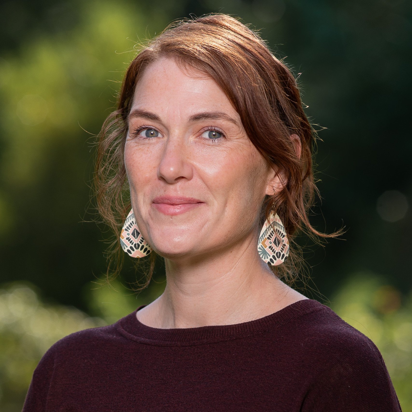 a woman with red hair wearing earrings