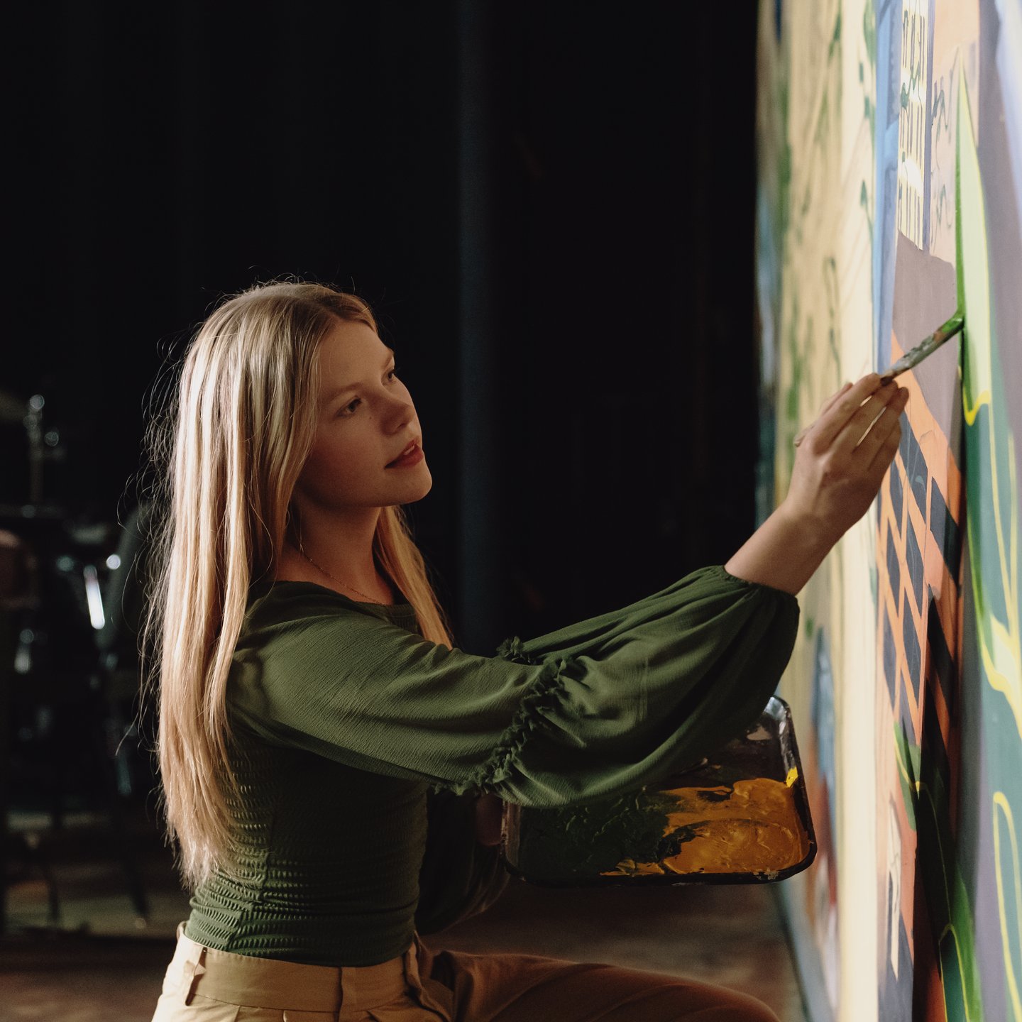 a woman painting on a wall