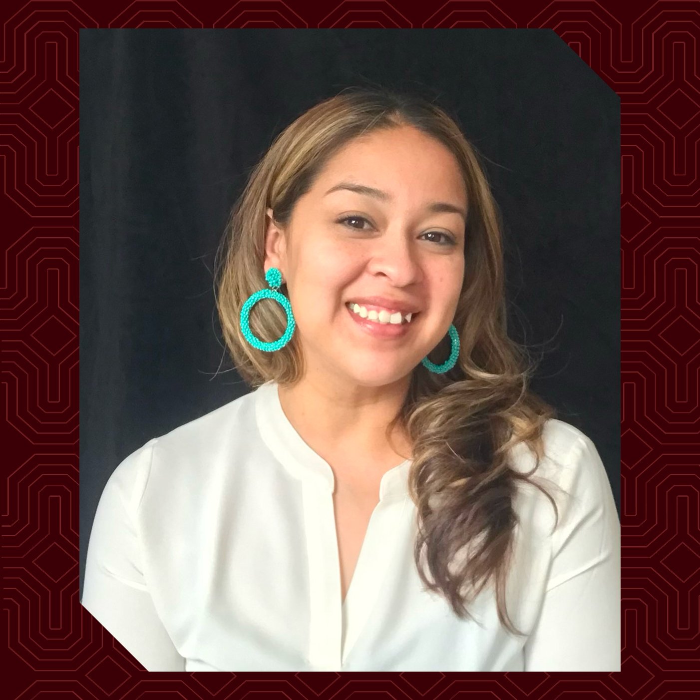 a woman smiling with large earrings