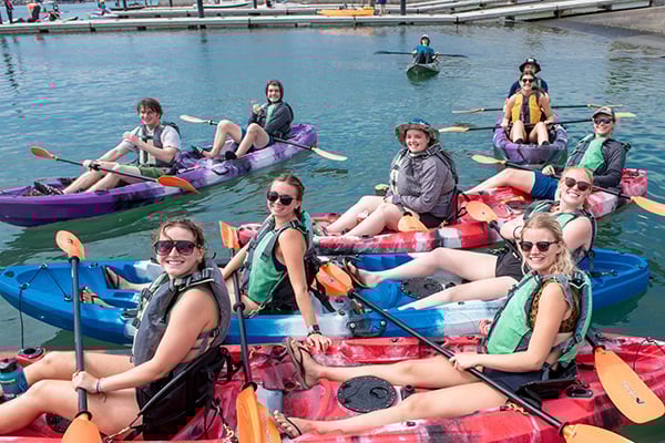 a group of people in kayaks on water