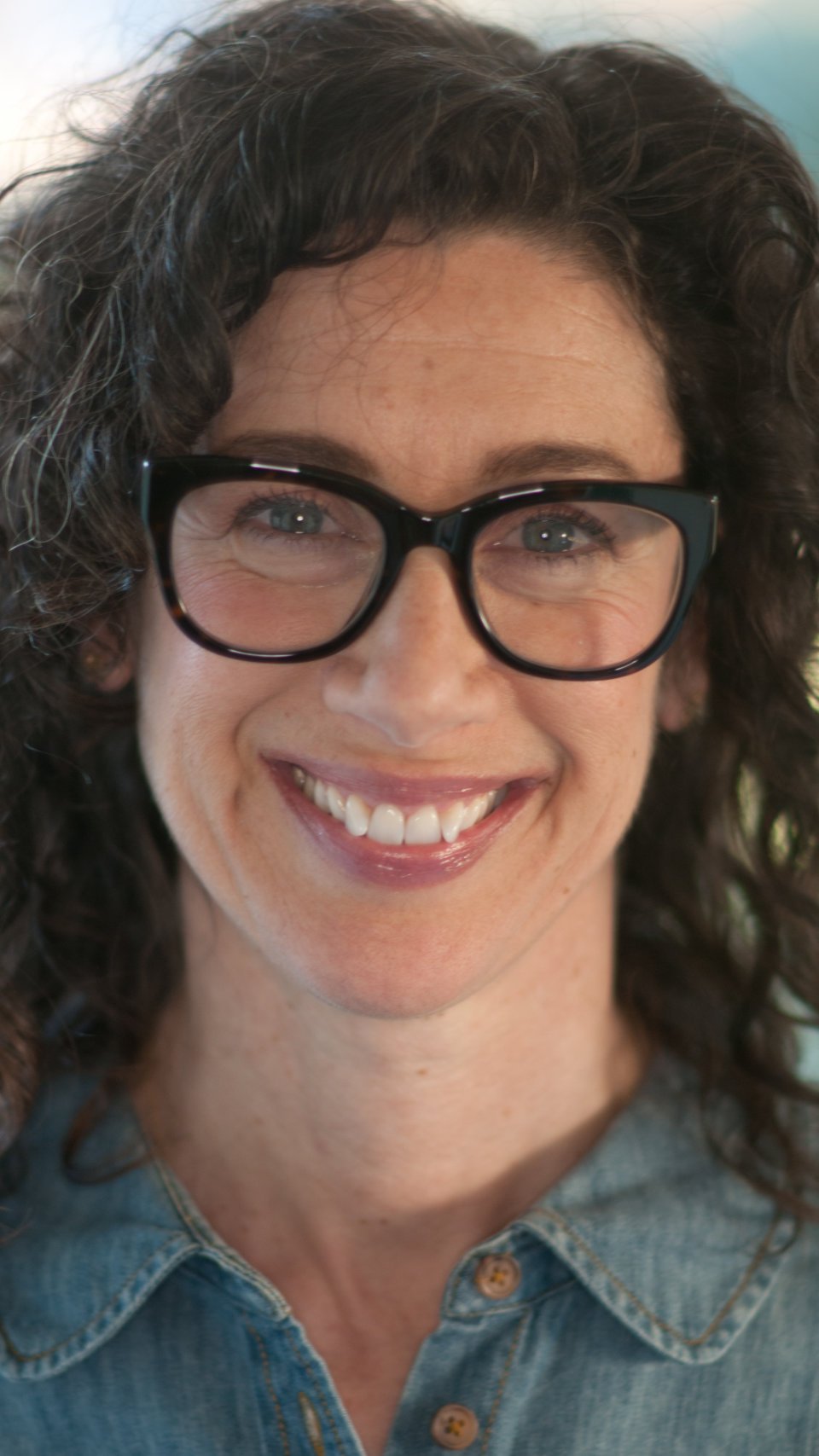 a woman wearing glasses smiling