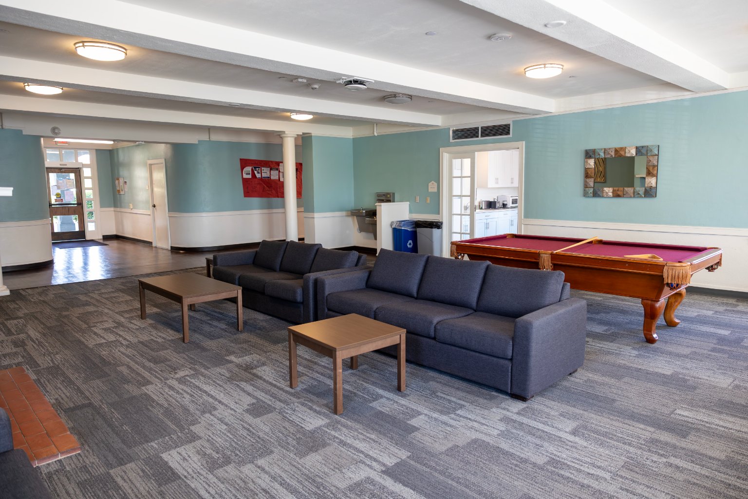 a room with a pool table and couches