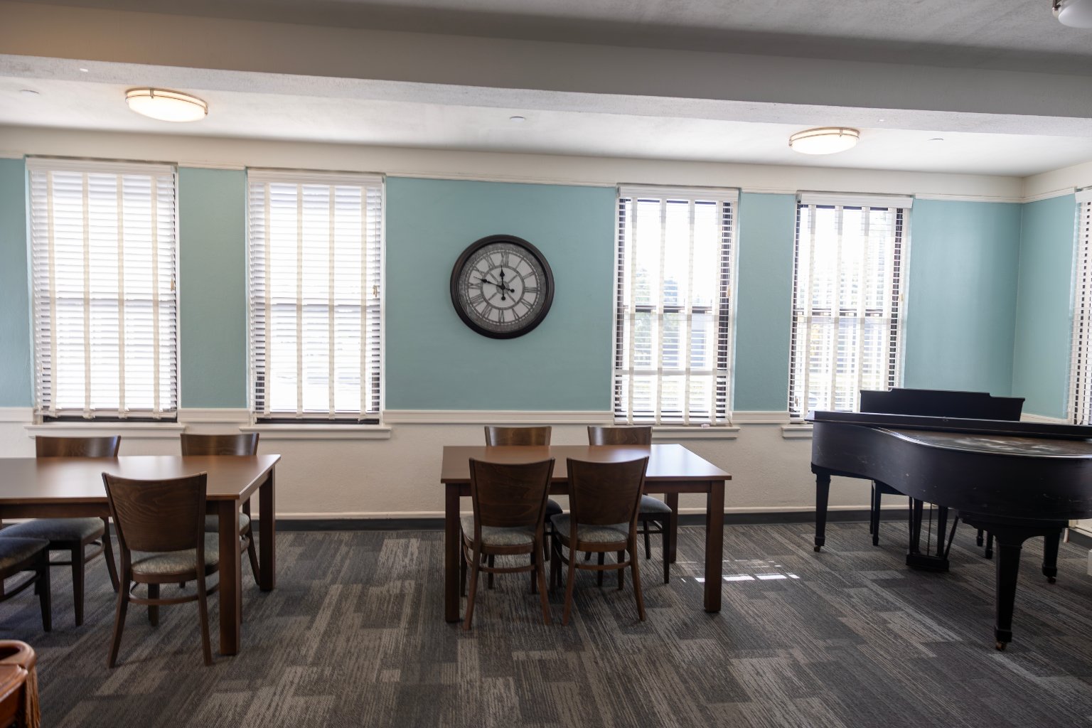 a room with a piano and chairs