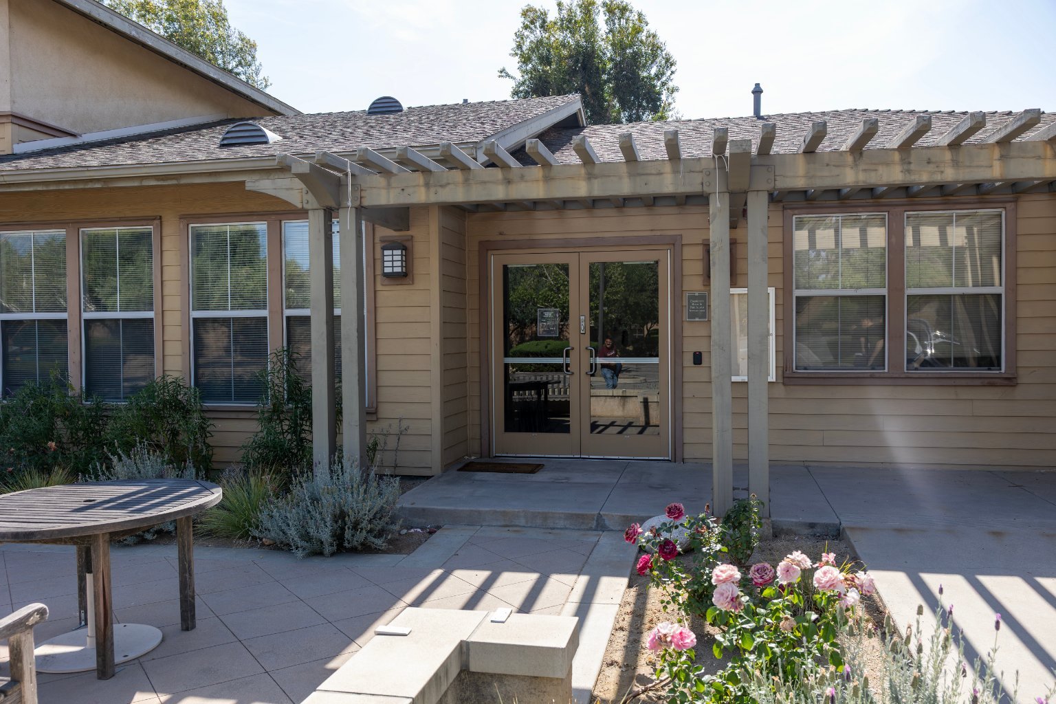 a house with a pergola and flowers