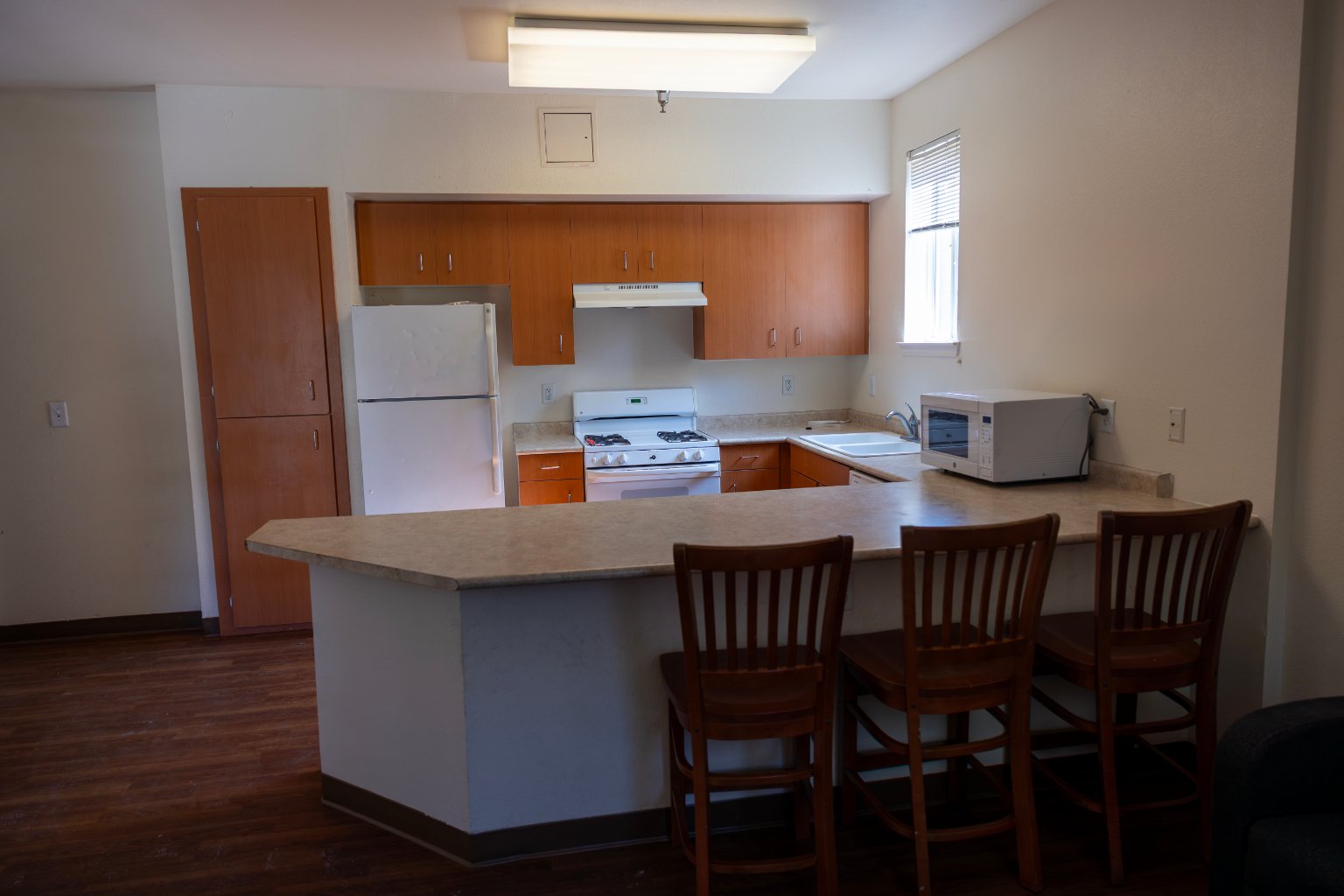 a kitchen with a bar and chairs