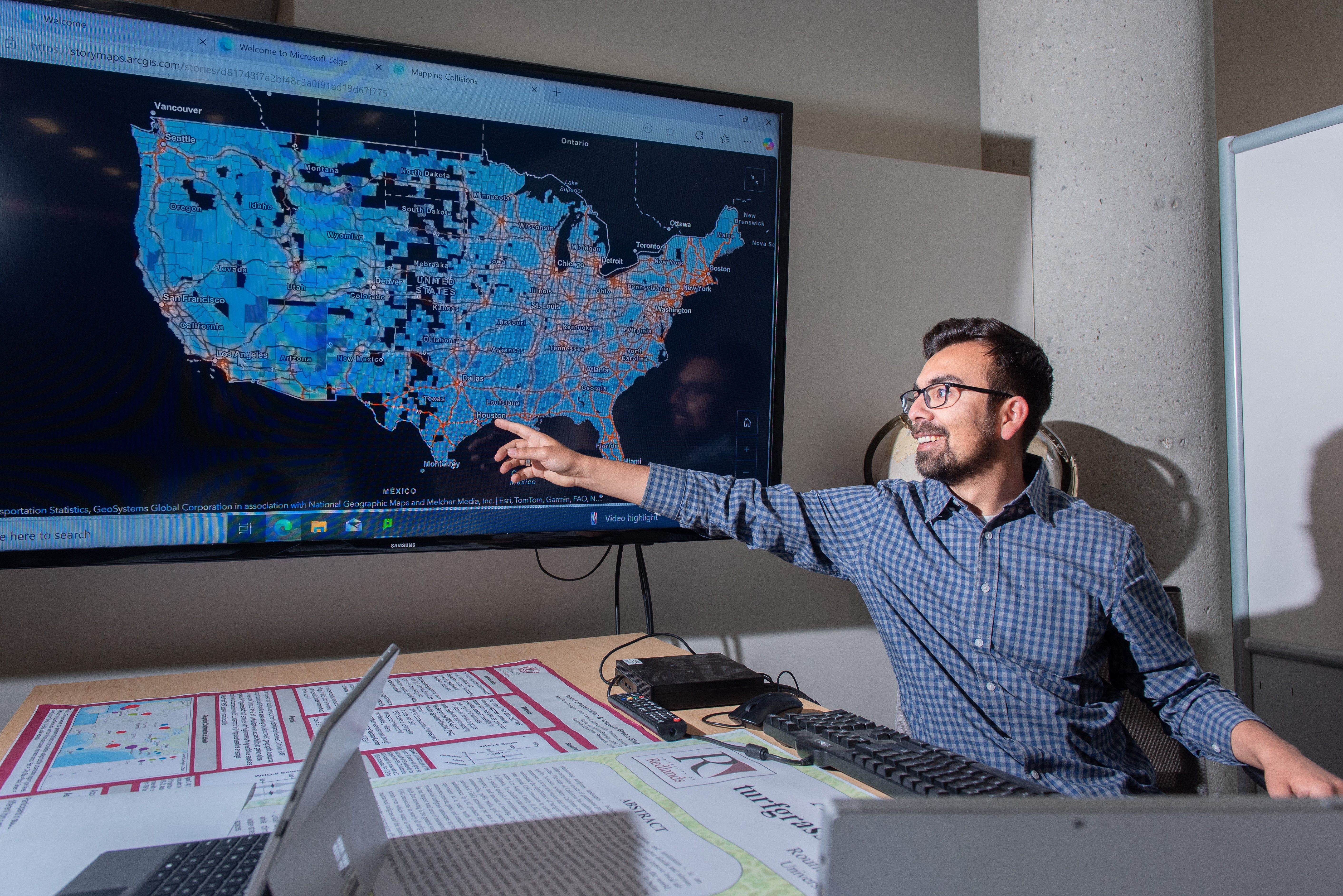 instructor pointing at interactive map on TV display