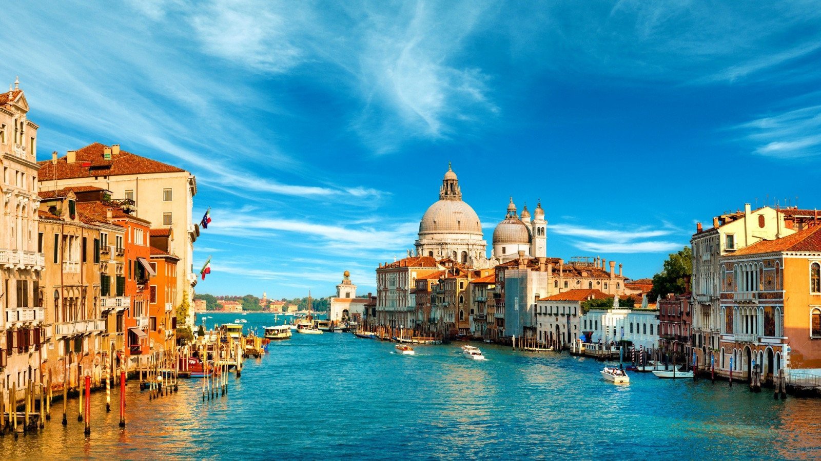 a water way with boats and buildings in the background with Grand Canal in the background