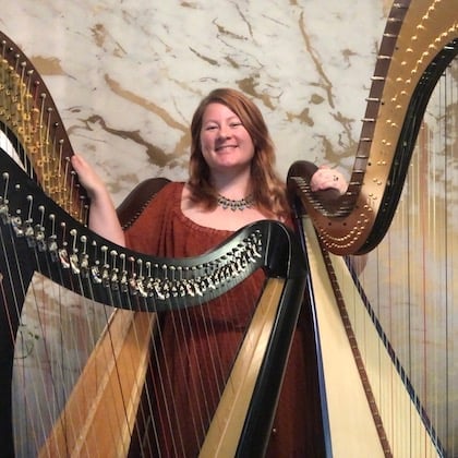 a woman standing next to a group of harps