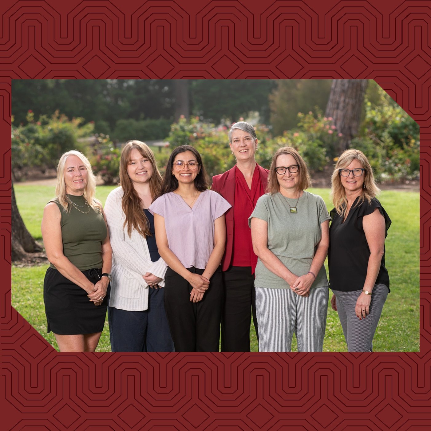a group of women standing together in a park