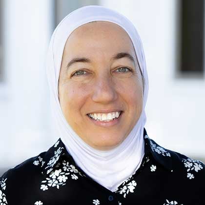 a woman wearing a white scarf and black shirt