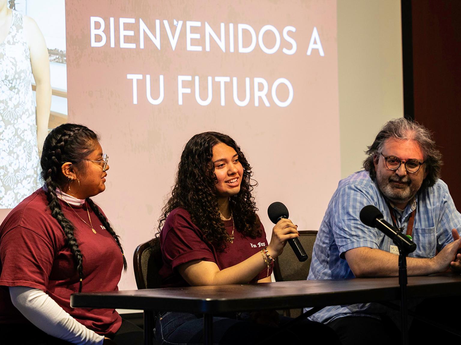 a group of people sitting at a table with microphones