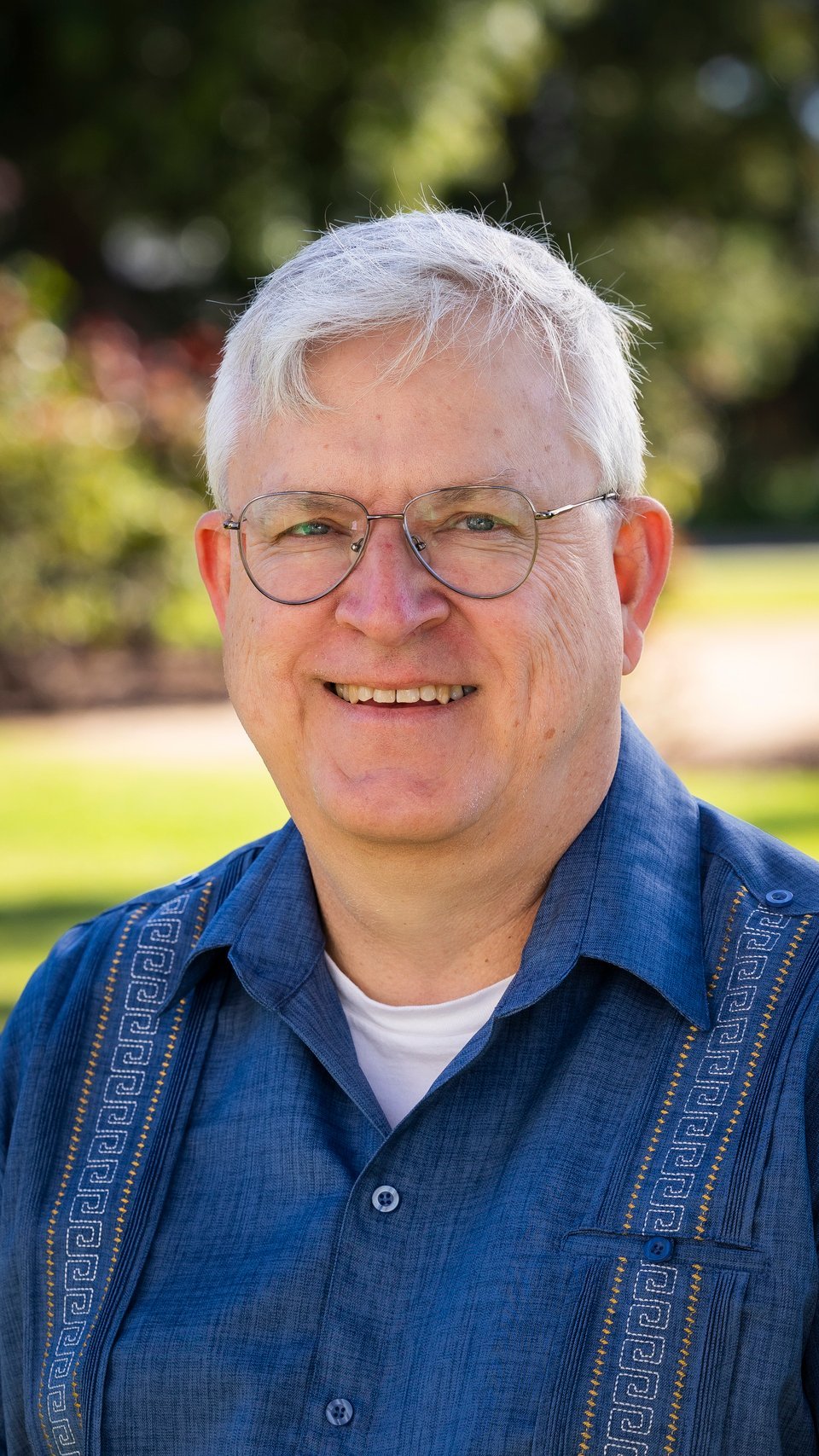 a man wearing glasses and smiling