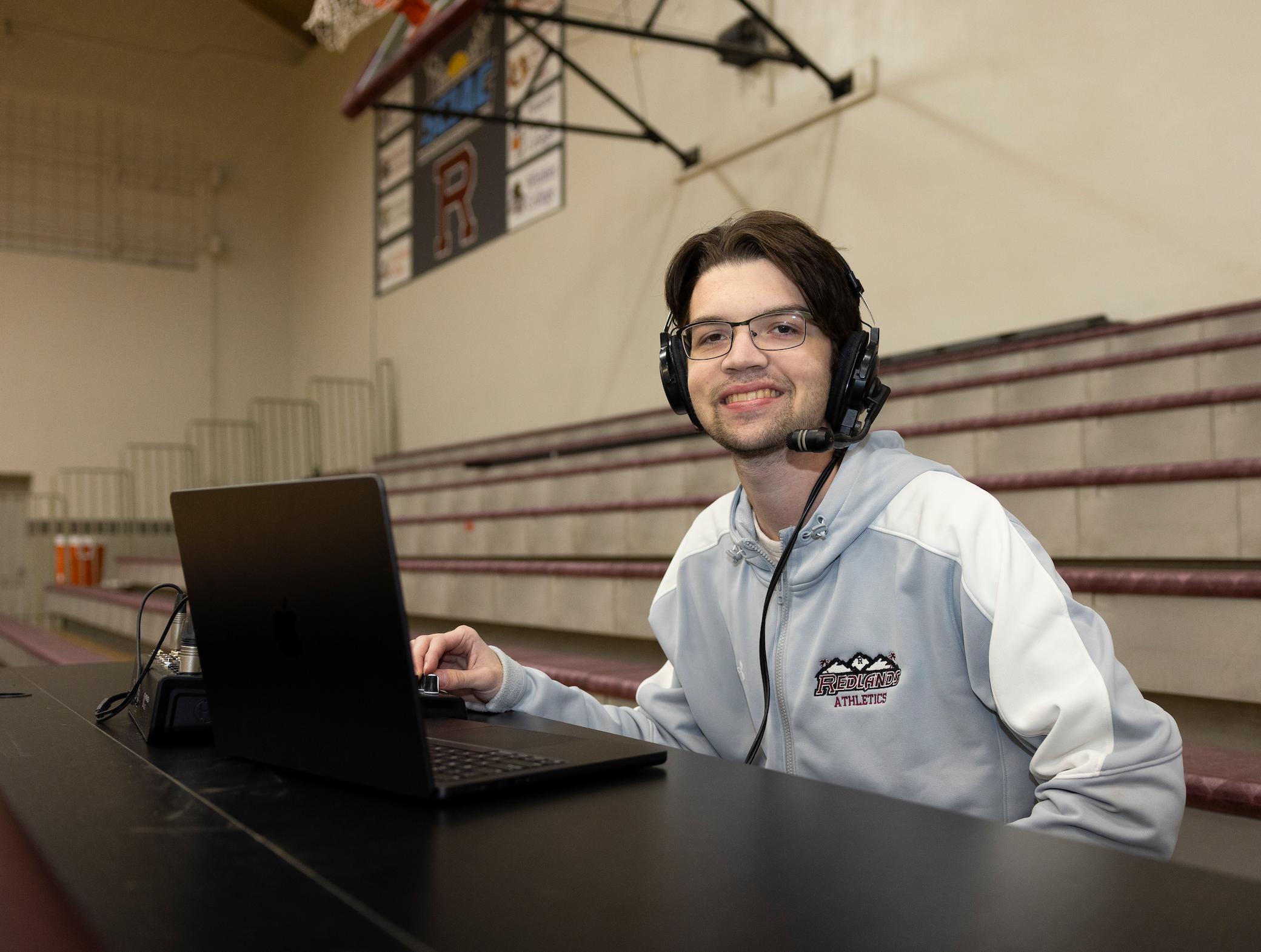 a man wearing headphones and using a laptop