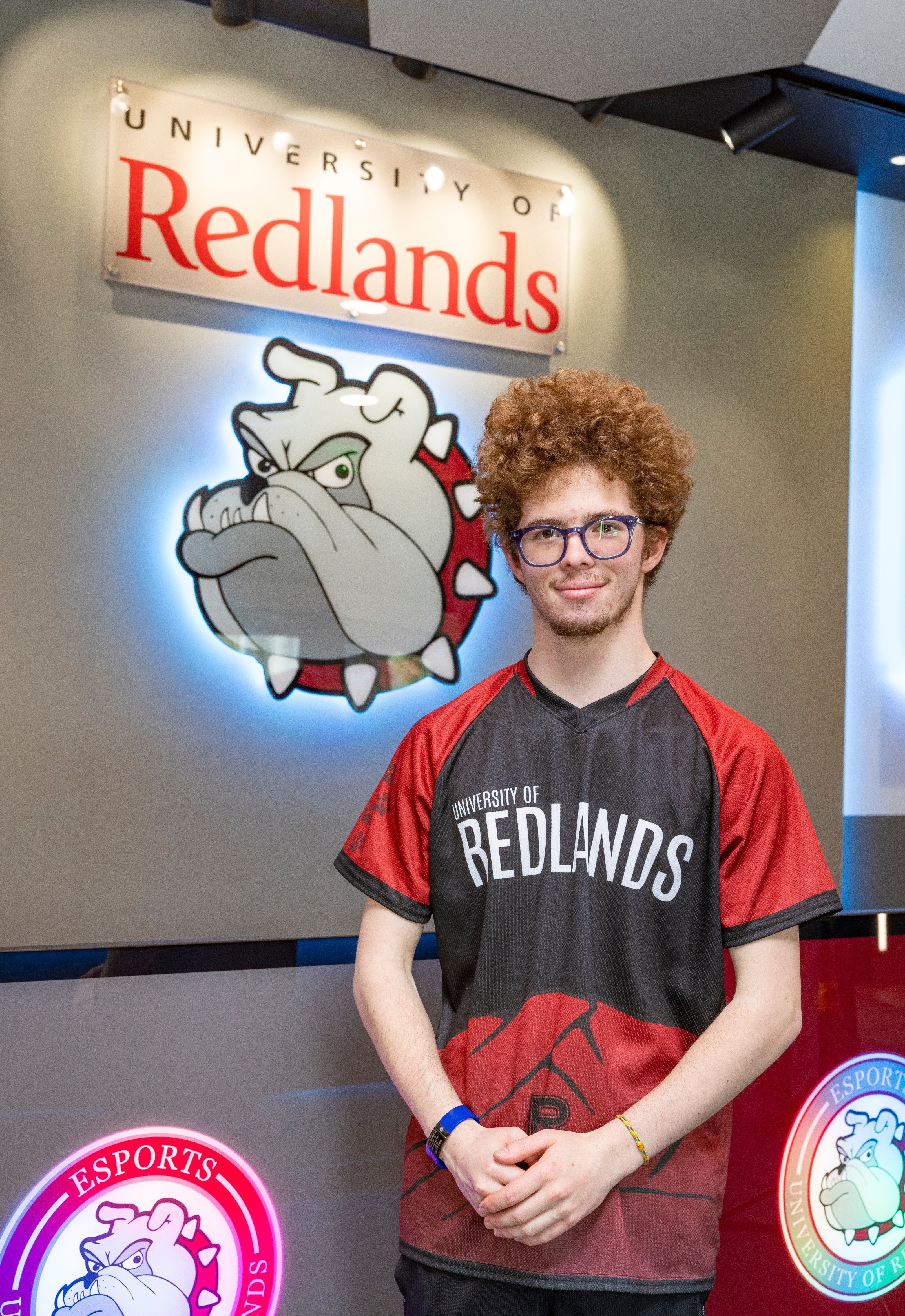 a man with curly hair wearing a red and black jersey