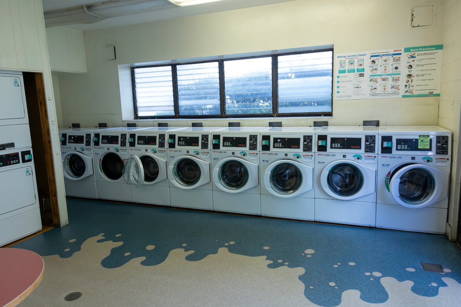 a row of washing machines in a laundry room