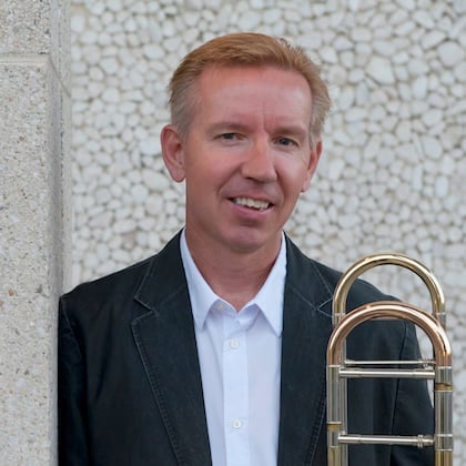 a man standing next to a trumpet
